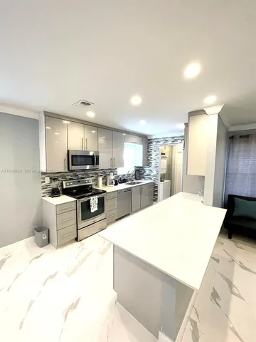 a large kitchen with a large counter top appliances and cabinets