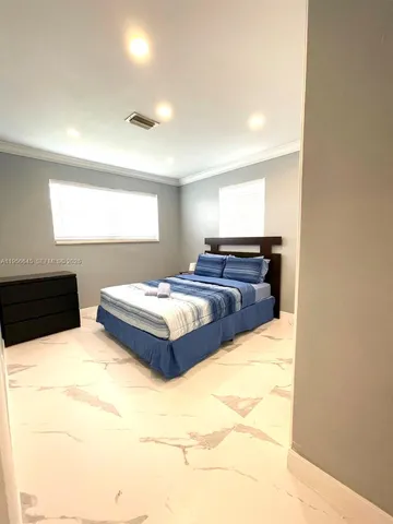 a spacious bedroom with a bed and window