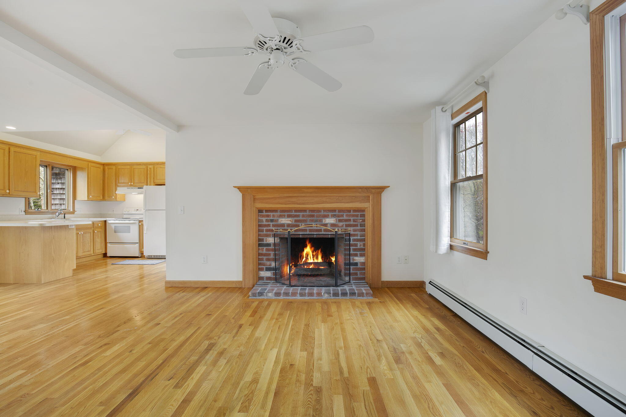 65 Whitney Road Eastham, MA 02642 - Photo 15 of 41 wooden floor fireplace and windows in an empty room