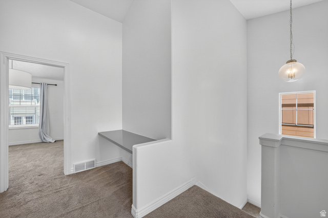 14771 Haddington Road Draper, UT 84020 - Photo 26 of 44 Loft area featuring a built-in desk with a gray surface, textured carpet flooring, and a contemporary glass pendant light fixture