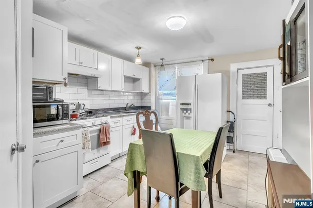 a kitchen with a table chairs refrigerator and cabinets