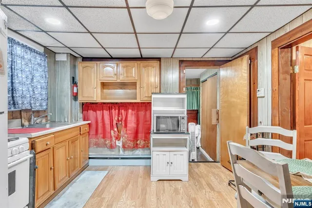 a kitchen with stainless steel appliances granite countertop a refrigerator a sink dishwasher a stove with white cabinets and wooden floor