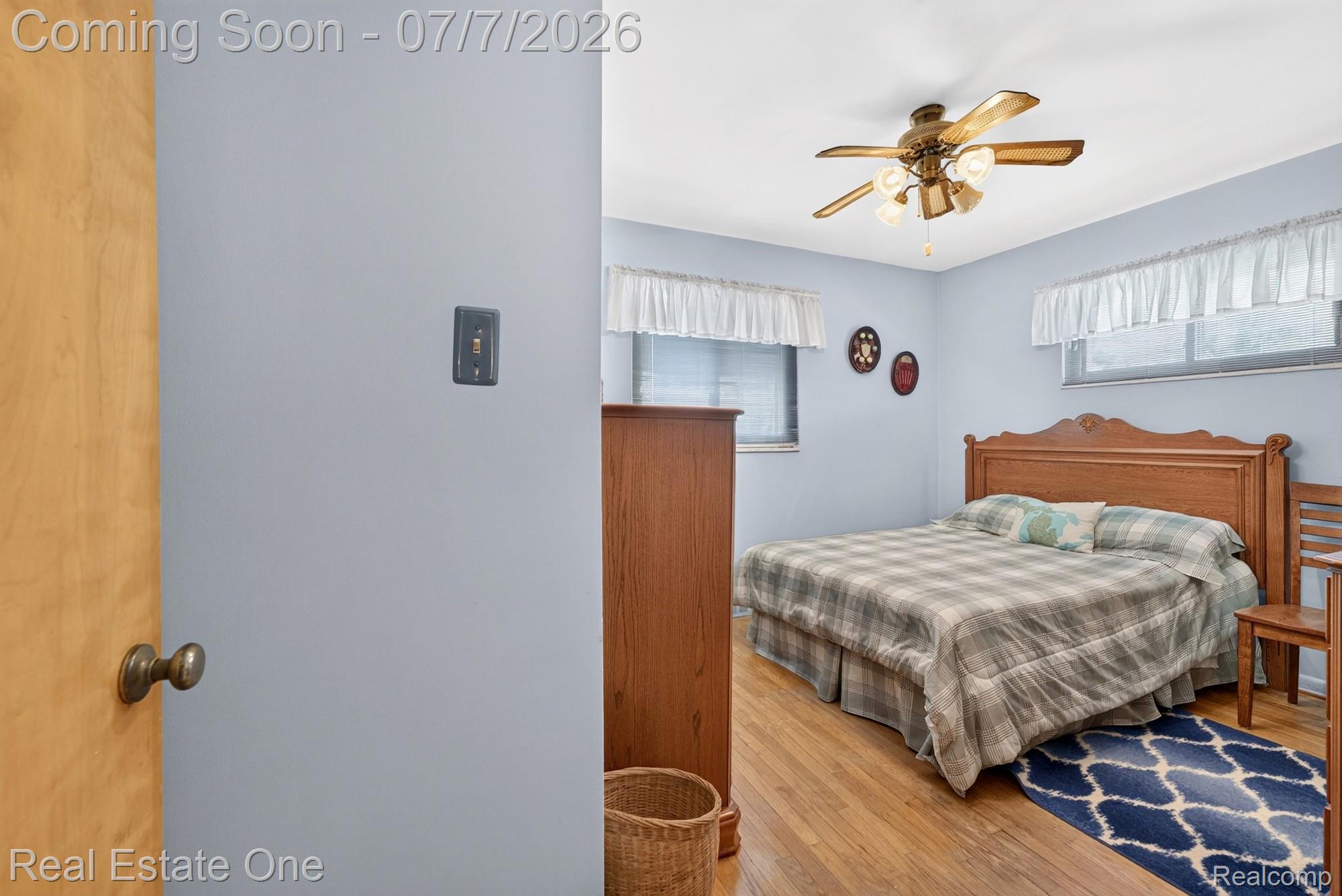 24749 Munson Street Taylor, MI 48180 - Photo 12 of 28 Bedroom featuring wood-finish flooring, a ceiling fan with integrated lighting, and two windows with valances