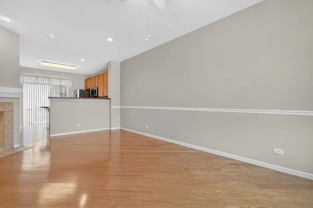 a view of a livingroom with wooden floor and a ceiling fan