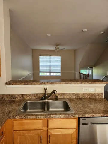 a kitchen with granite countertop a sink and a wooden cabinets