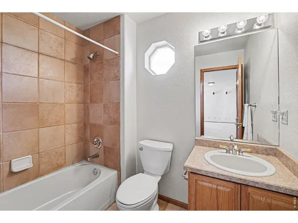 a bathroom with a sink a toilet a mirror and shower