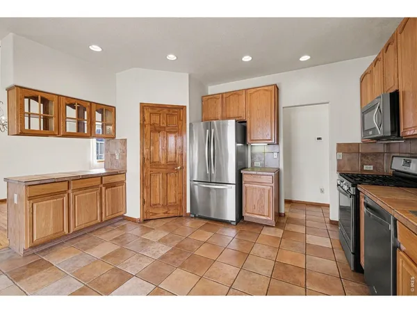 a kitchen with stainless steel appliances granite countertop a refrigerator a stove a sink and a microwave