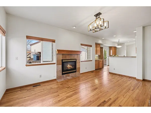 a view of an empty room with a kitchen and a window