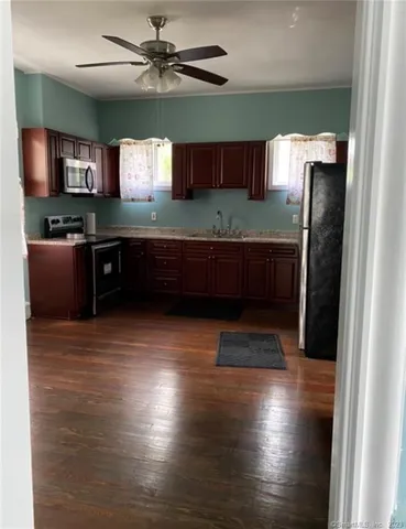 a kitchen with stainless steel appliances granite countertop a refrigerator a sink and a stove