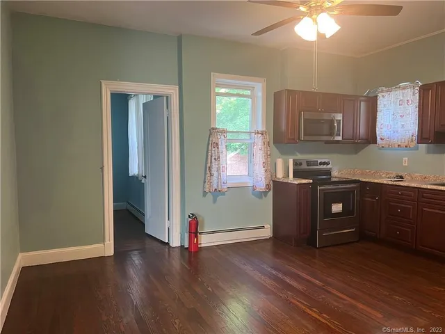 a kitchen with stainless steel appliances granite countertop a refrigerator a sink dishwasher a stove with wooden cabinets and floor