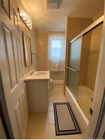 a bathroom with a tub a sink and a mirror