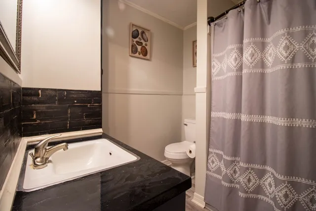 a bathroom with a sink toilet and shower