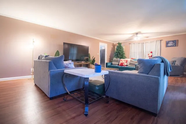 a living room with furniture and a wooden floor