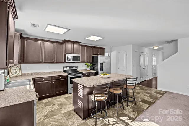 a kitchen with granite countertop a stove sink and cabinets