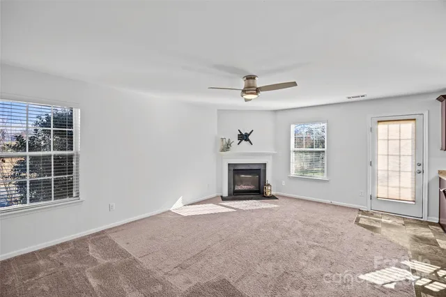 an empty room with windows and fan