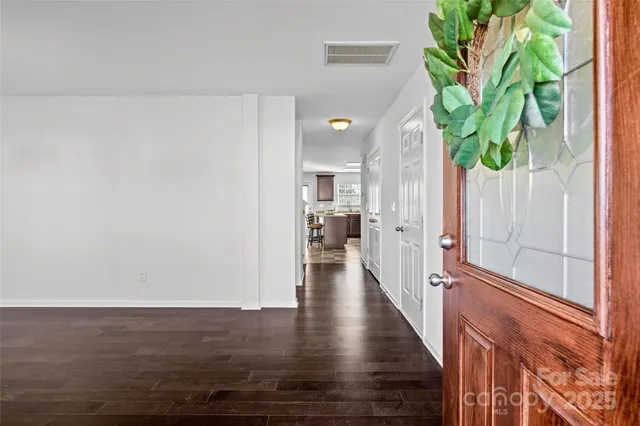 a view of a hallway with wooden floor and plant