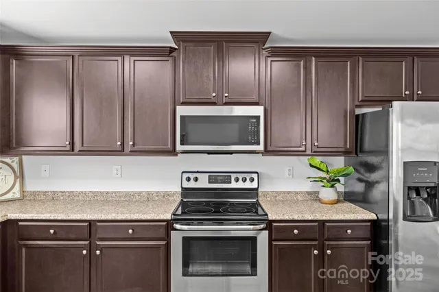 a kitchen with granite countertop a stove sink and cabinets