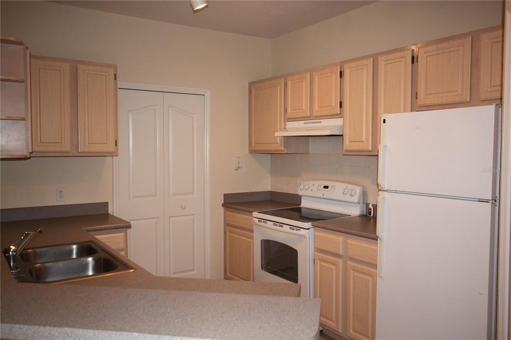 5811 Legacy Crescent Place, Unit 202 Riverview, FL 33578 - Photo 2 of 12 a kitchen with a refrigerator sink stove and cabinets