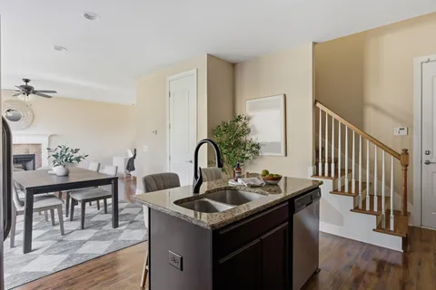 a view of kitchen island with sink and wooden floor