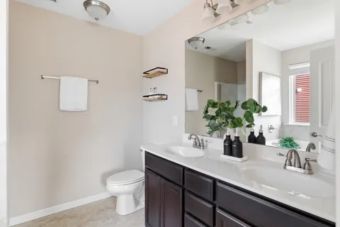 a bathroom with a sink a toilet and a mirror