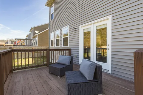 a view of a deck with wooden floor and a lounge chair