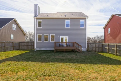 a view of a house with backyard and a tree