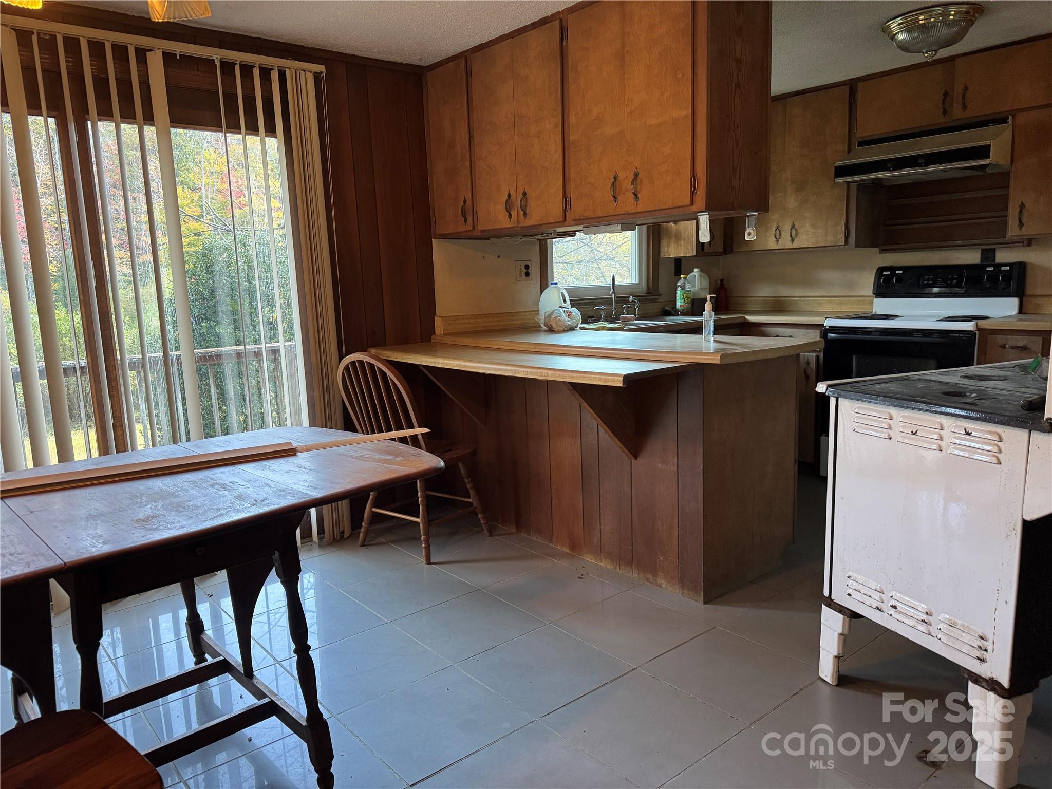 147 Helton Lane Mill Spring, NC 28756 - Photo 15 of 25 a kitchen with a table chairs sink and cabinets