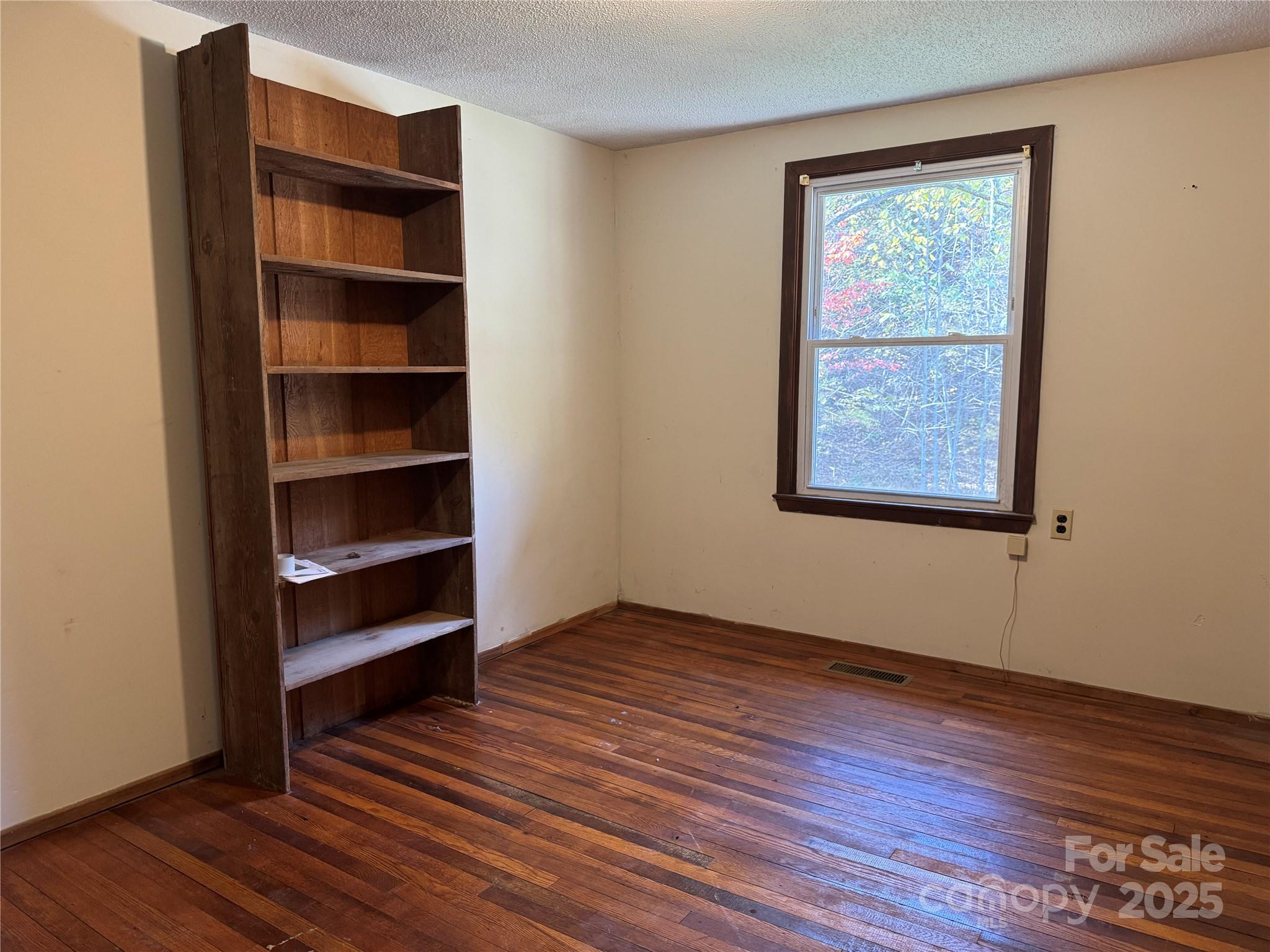 147 Helton Lane Mill Spring, NC 28756 - Photo 18 of 25 a view of an empty room with wooden floor and a window