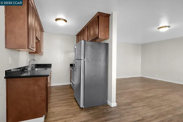 a view of a kitchen with wooden floor and electronic appliances