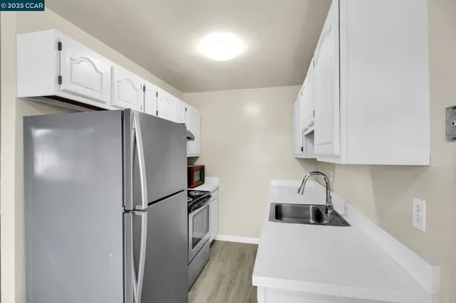 a kitchen with white cabinets and stainless steel appliances