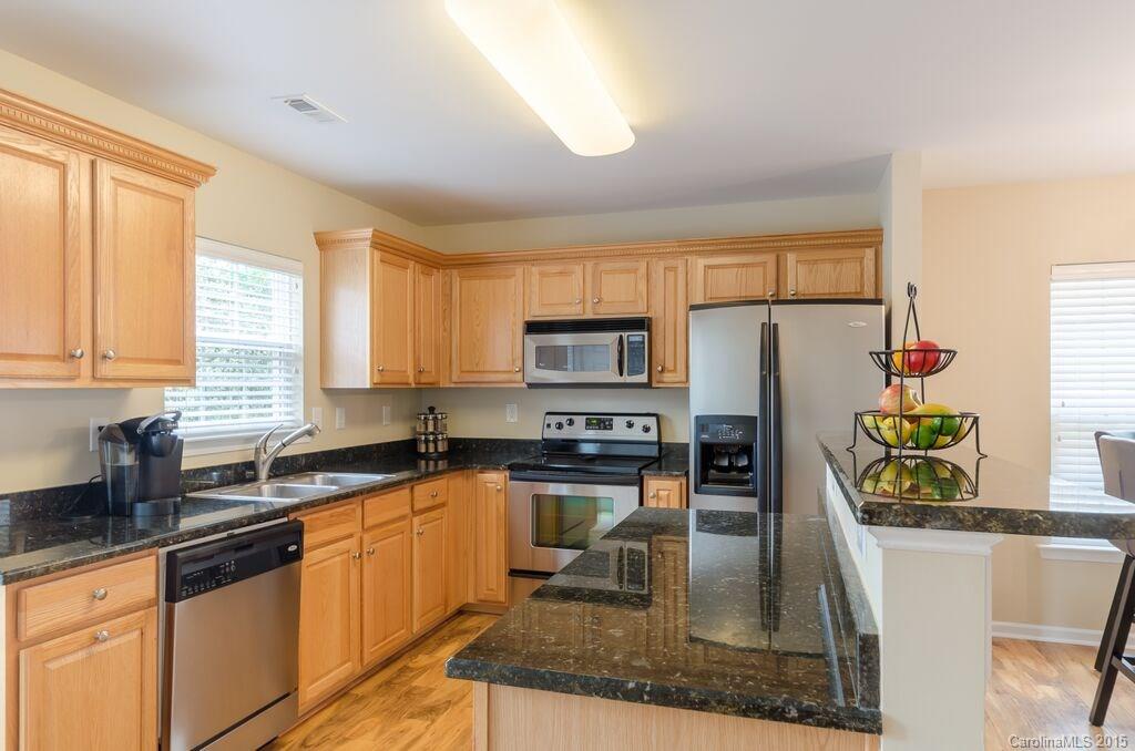 10012 Caldwell Depot Road Cornelius, NC 28031 - Photo 7 of 20 a kitchen with stainless steel appliances granite countertop a sink a stove a microwave a refrigerator a counter space and cabinets