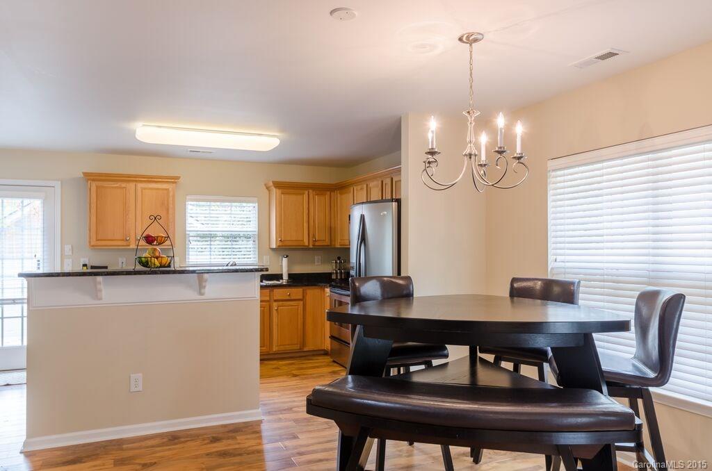 10012 Caldwell Depot Road Cornelius, NC 28031 - Photo 10 of 20 a view of a dining room with furniture and wooden floor