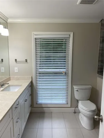 a bathroom with a granite countertop toilet a sink and a mirror