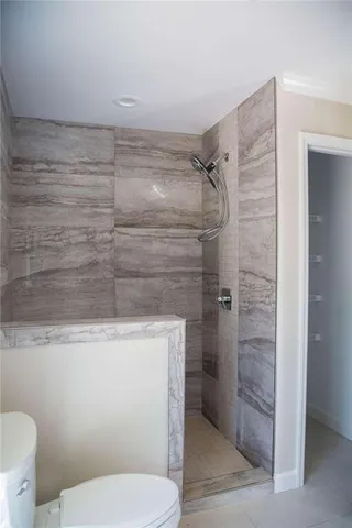 a bathroom with a granite countertop shower toilet and sink