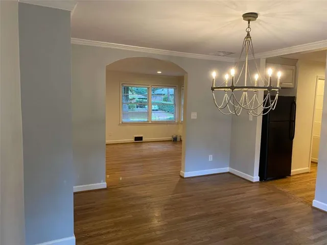 a view of a room with wooden floor and ceiling fan