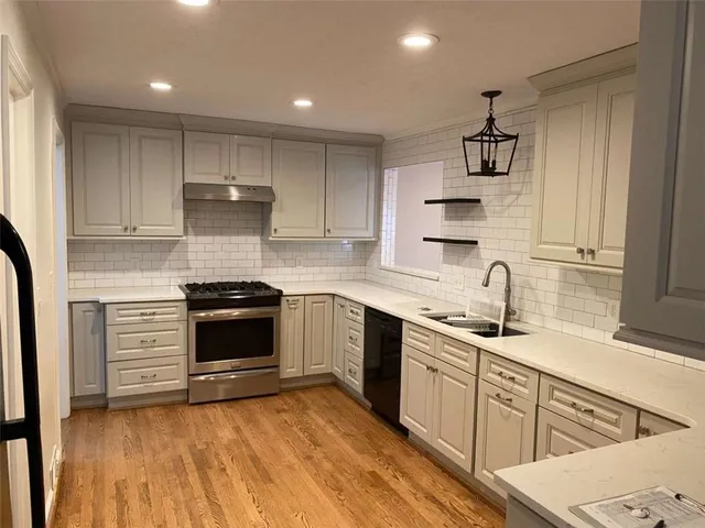 a kitchen with stainless steel appliances granite countertop a sink stove and cabinets