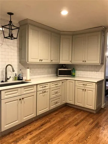 a kitchen with granite countertop white cabinets and white appliances