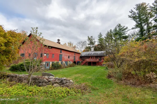 a view of a house with a big yard and large trees