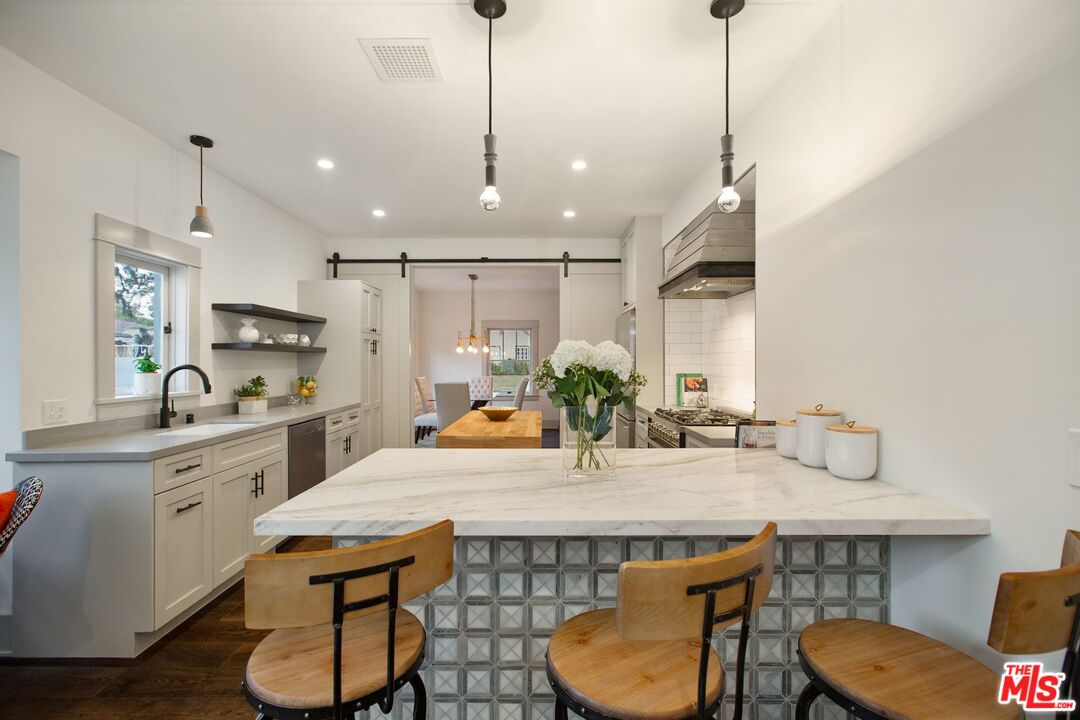 403 North Irving Boulevard Los Angeles, CA 90004 - Photo 22 of 46 a kitchen with stainless steel appliances granite countertop a sink a stove and chairs