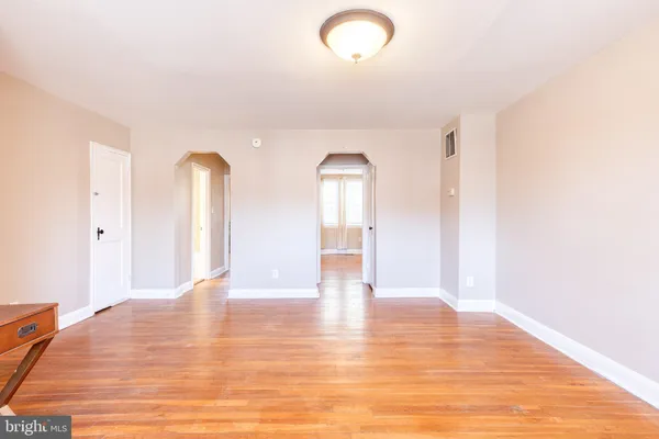 a view of empty room with wooden floor