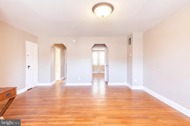 a view of empty room with wooden floor