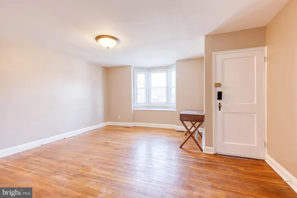 a view of a livingroom with wooden floor and a window