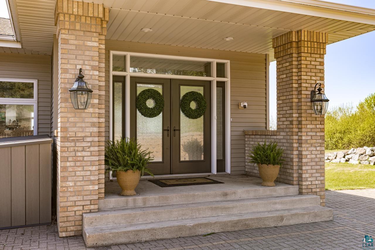 2906 West 15th Street Duluth, MN 55811 - Photo 4 of 98 Brick-clad entry columns frame the double front doors with clear glass panels and transom windows