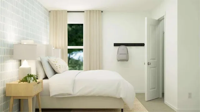 a large white bed in a bathroom next to a window