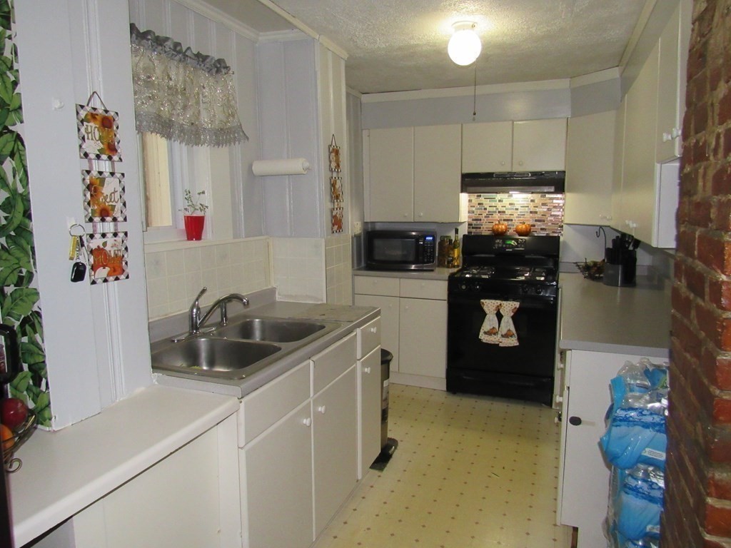 1-3 Walnut Street Methuen, MA 01844 - Photo 18 of 20 a kitchen with stainless steel appliances a sink a stove and a refrigerator