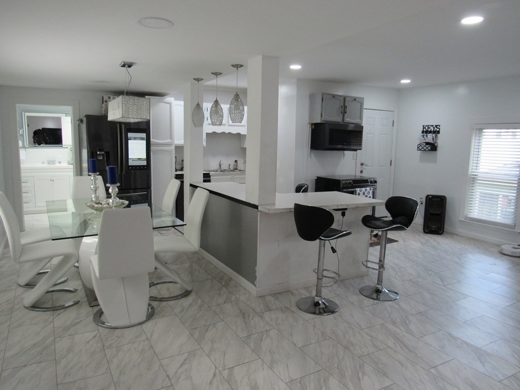 1-3 Walnut Street Methuen, MA 01844 - Photo 4 of 20 a view of a kitchen with dining room and wooden floor