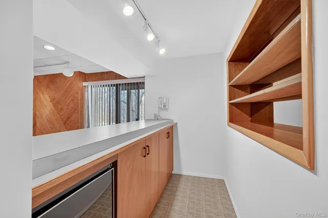 an empty room with wooden floor closet and windows