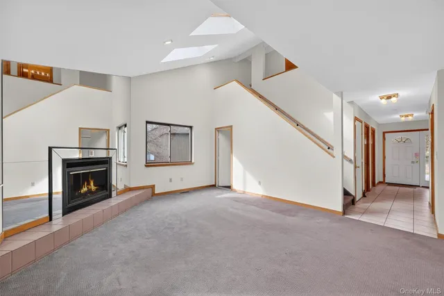 a view of an empty room with window and fireplace