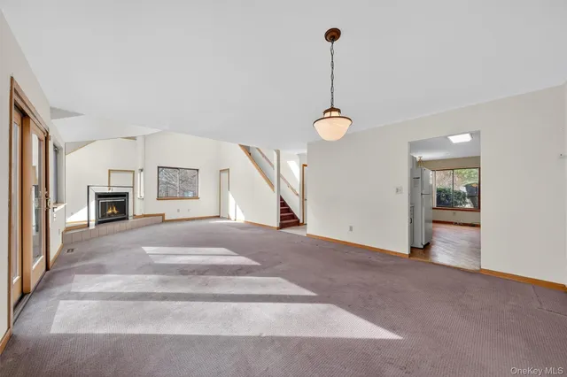 a view of an empty room with fireplace and a window