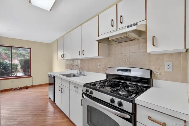 a kitchen with a sink a stove a refrigerator and cabinets